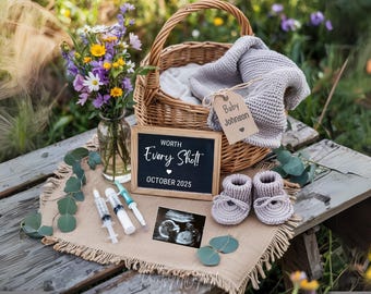 May include: A chalkboard sign with the text "Worth Every Shot! October 2025" sits on a wooden table with a basket of baby clothes, a small ultrasound image, and two syringes. The basket is decorated with a tag that reads "Baby Johnson".