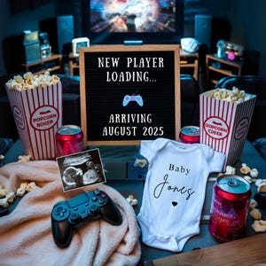 May include: A pregnancy announcement with a gaming theme, featuring popcorn, soft drinks, and a baby onesie. A letter board displays "NEW PLAYER LOADING... ARRIVING AUGUST 2025." A sonogram and a game controller are also visible.