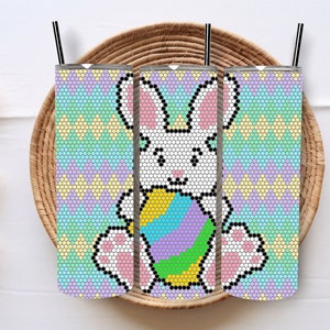 May include: Three pastel-coloured insulated tumblers with a white bunny holding a colourful Easter egg. The tumblers have a geometric pattern.