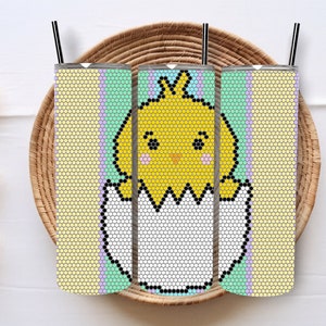 Puede incluir: Tres vasos de acero inoxidable de color pastel con un diseño de un pollito amarillo saliendo de un huevo. Los vasos tienen un fondo blanco con rayas de color verde pastel, morado y amarillo.