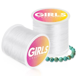 May include: Two spools of clear elastic string with the label "GIRLS CREATIVITY" on the front. A turquoise beaded bracelet is in the foreground.