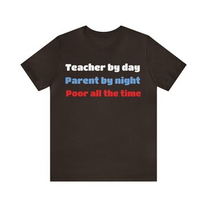 Może przedstawiać: Czarny T-shirt z białym tekstem, który brzmi "Teacher by day Parent by night Poor all the time".