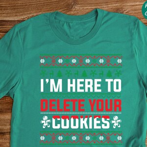 May include: A Kelly Green t-shirt with the text "I'M HERE TO DELETE YOUR COOKIES" in white and red. The shirt has a festive design with snowflakes and gingerbread men, perfect for the holiday season.