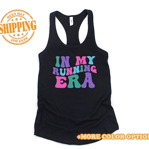 May include: Black tank top with the text "IN MY RUNNING ERA" in colorful, retro-style letters.