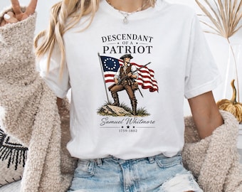 May include: White t-shirt featuring a graphic of a colonial soldier holding a flag with the text "Descendant of a Patriot" and the name "Samuel Whitmore 1759-1802". The design is in shades of brown, red, blue, and white.