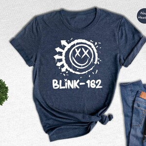 a t - shirt that says blink - 1932 next to a pair of jeans and