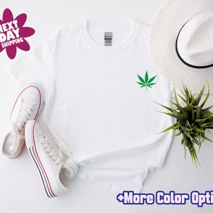 May include: White t-shirt with a green marijuana leaf graphic on the front.  +More Color Options