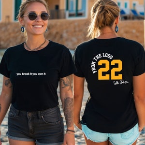 May include: Black t-shirt with white text "you break it you own it" on the front and yellow text "FROM THE LOGO 22" on the back. The back also has a signature.