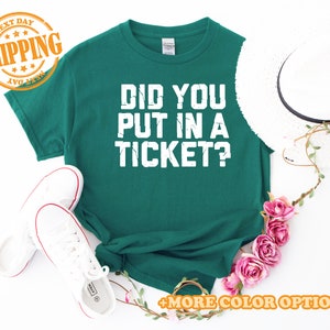 May include: A green t-shirt with white text that reads "Did you put in a ticket?"