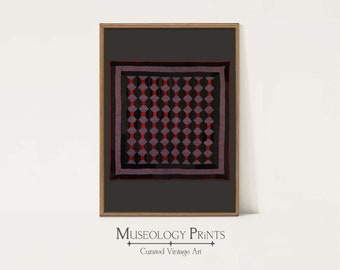 May include: A framed print of a vintage quilt with a geometric pattern in shades of red, black, and purple. The quilt is framed in a wooden frame with a black mat. The print is titled "Museology Prints: Curated Vintage Art".