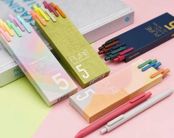 May include: Five packs of gel ink pens in different colors. Each pack has a different color scheme and features the word "PURE" and the number "5" on the packaging.