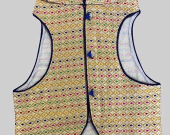 May include: A sleeveless vest with a mandarin collar and a geometric pattern in shades of gold, pink, blue, and green. The vest has a blue button closure and a navy blue trim.
