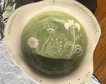 Deep ceramic plate with a light green sgraffito decoration.