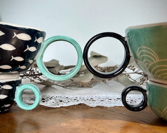 White + color ceramic circle mugs with sgraffito decoration