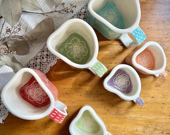 White + colored ceramic mugs with sgraffito decoration