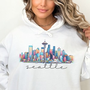 A Seattle sweatshirt with a colorful rendition of the city's skyline and the name Seattle in text. Available as a crewneck sweatshirt or hoodie.