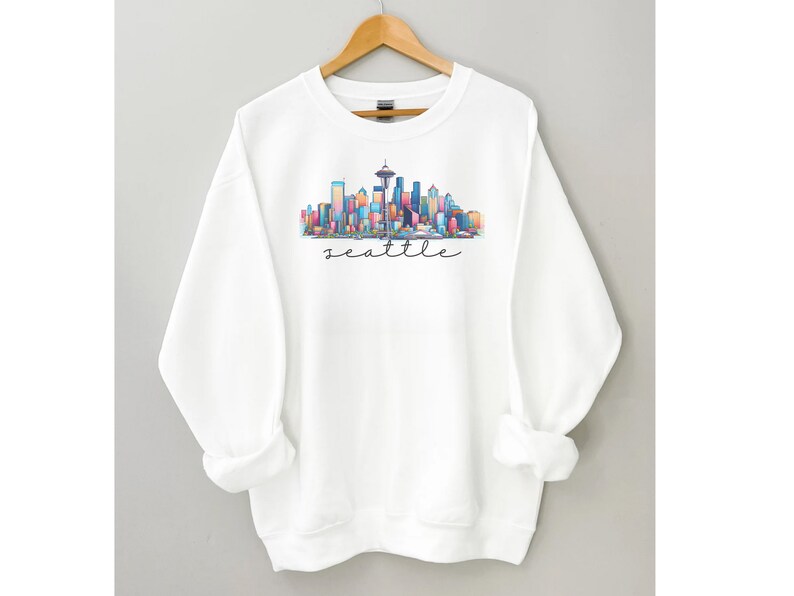 A Seattle sweatshirt with a colorful rendition of the city's skyline and the name Seattle in text. Available as a crewneck sweatshirt or hoodie.