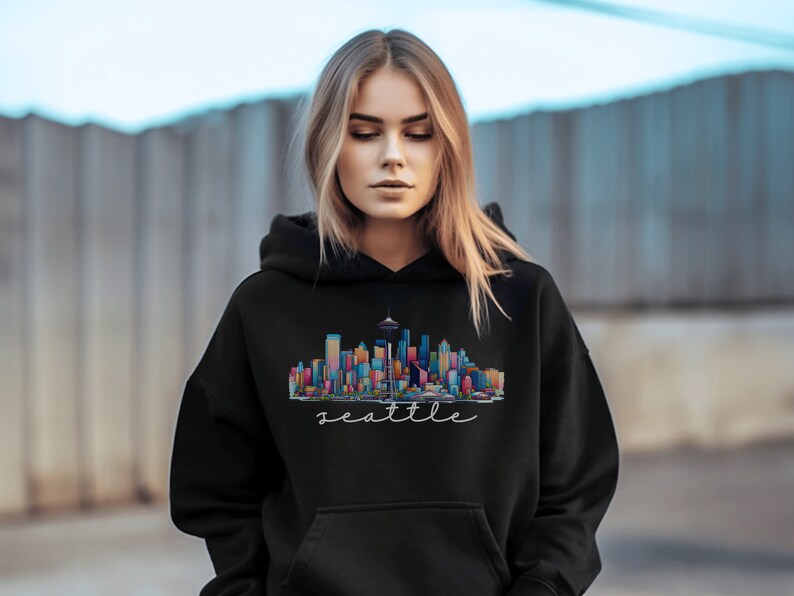 A Seattle sweatshirt with a colorful rendition of the city's skyline and the name Seattle in text. Available as a crewneck sweatshirt or hoodie.