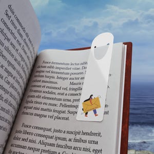 Puede incluir: Marcapáginas blanco con una parte superior recortada, con una ilustración de una persona que lleva un sobre amarillo grande con el texto "YOUR MAIL POST". El marcapáginas está colocado en un libro abierto con texto.