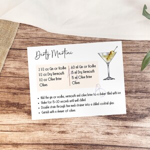May include: A printable recipe card for a Dirty Martini cocktail. The card features a hand-drawn illustration of a martini glass with an olive garnish. The recipe includes ingredients and instructions for making the cocktail, including 60 ml of gin or vodka, 15 ml of dry vermouth, 15 ml of olive brine, and olives.