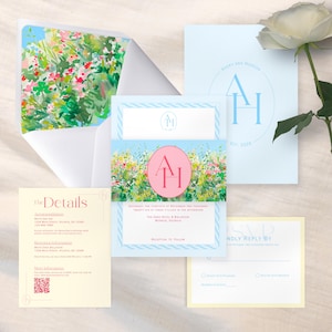 May include: A collection of wedding stationery featuring a floral design. The set includes invitations, RSVP cards, and details cards. The color palette is soft, with light blue, pink, and green accents. The invitation band features the initials "AH" in a pink circle.