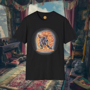 Puede incluir: Camiseta negra con un diseño gráfico circular de una deidad en un aura de fuego. La deidad está representada en tonos azules, naranjas y amarillos. La camiseta tiene cuello redondo y un pequeño emblema dorado cerca del cuello.