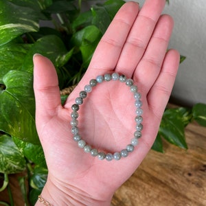 May include: A grey and black beaded bracelet made of labradorite stones.