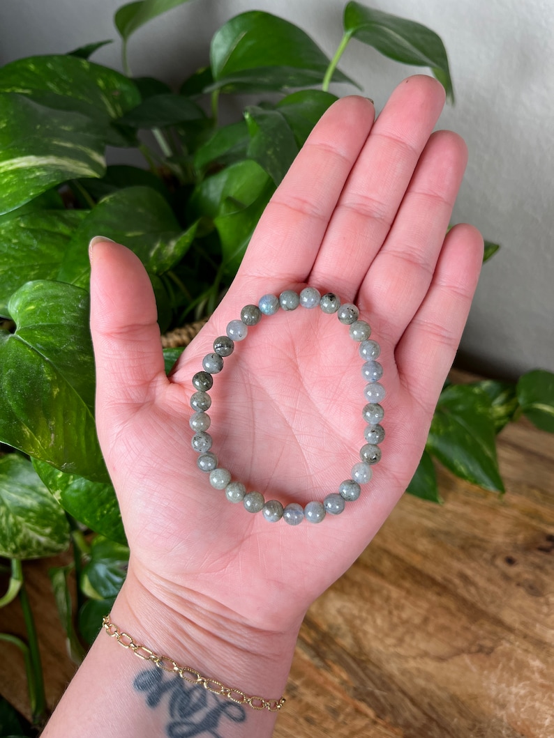 May include: A grey and black beaded bracelet made of labradorite stones.