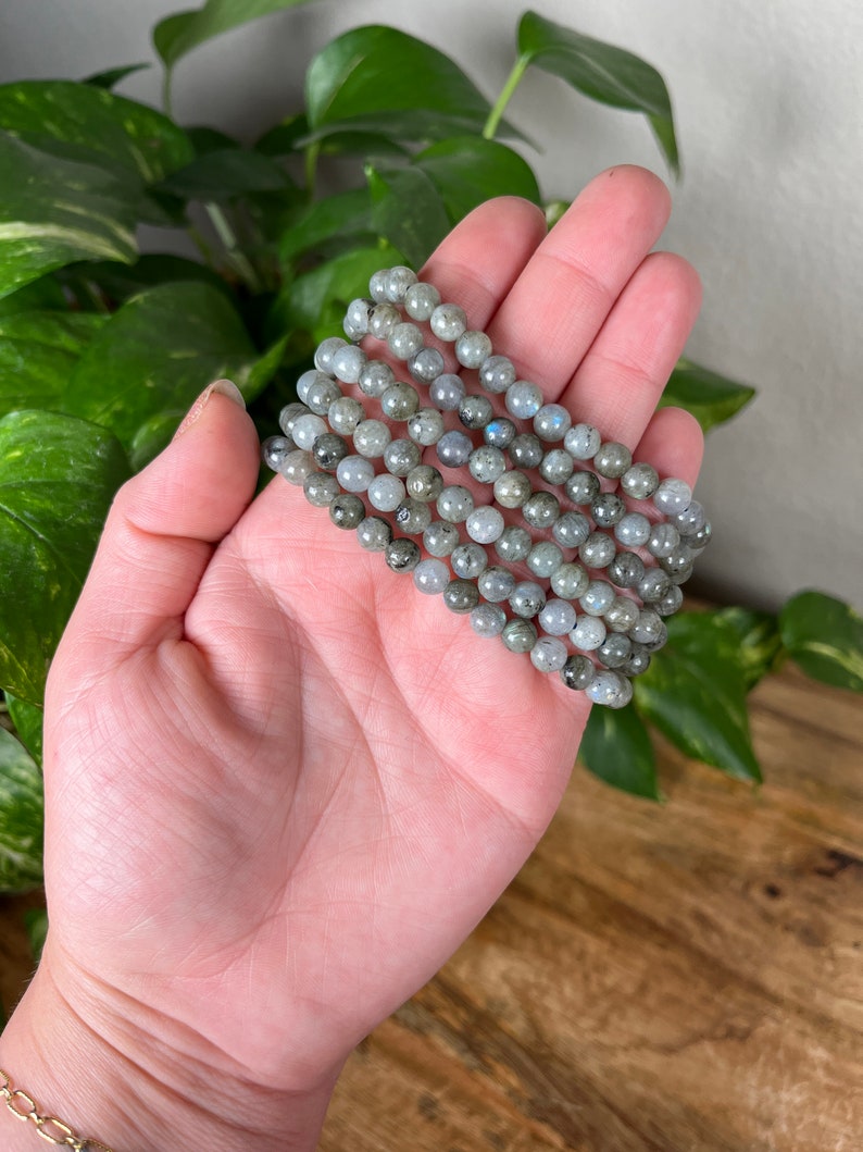 May include: A stack of six grey labradorite gemstone bracelets with a silver sheen.