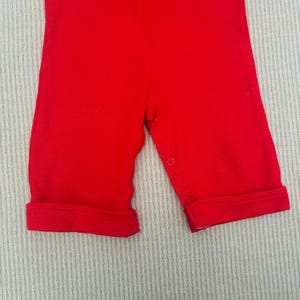 Puede incluir: Mono de beb&eacute; rojo con piernas con pu&ntilde;os y cierres a presi&oacute;n.