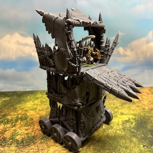 May include: A gray plastic model of a war machine with a raised platform and a ramp. The platform has a small figure of a warrior on it. The machine has wheels and is covered in spikes.