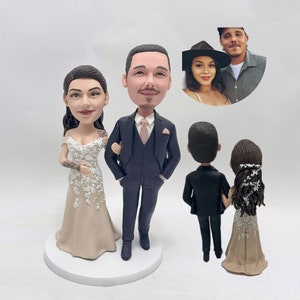 May include: A wedding cake topper featuring a bride and groom in a traditional wedding attire. The bride is wearing a beige dress with white lace details and the groom is wearing a black suit with a pink tie. The couple is also shown from the back, with the bride wearing a beige dress with white lace details and the groom wearing a black suit.
