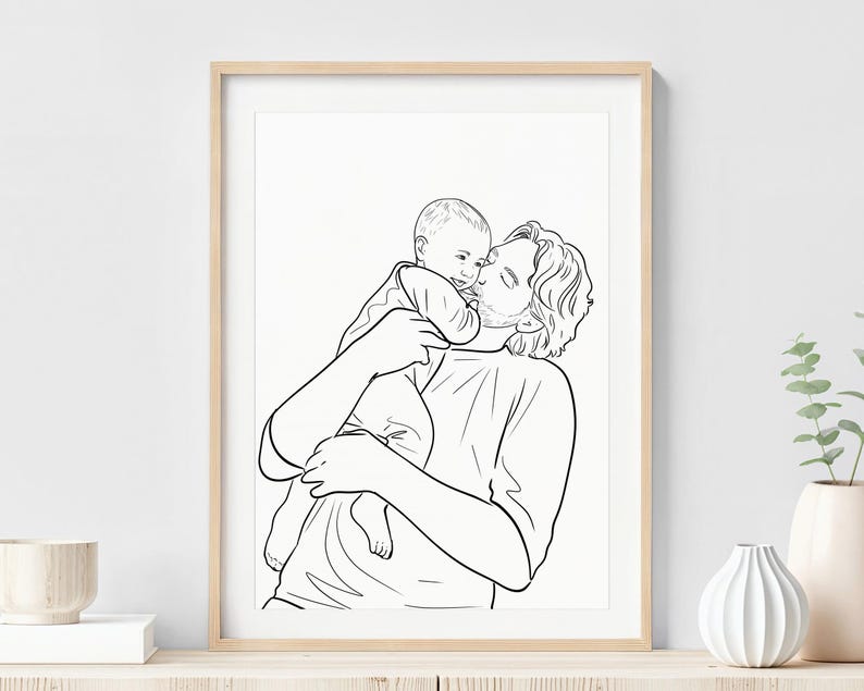 K&ouml;nnte beinhalten: Ein schwarz-wei&szlig;-Linienkunstdruck in einem hellen Holzrahmen. Das Kunstwerk zeigt eine Person, die ein Baby h&auml;lt und k&uuml;sst. Der Druck wird an einer wei&szlig;en Wand mit dekorativen Vasen und einem Holztisch ausgestellt.