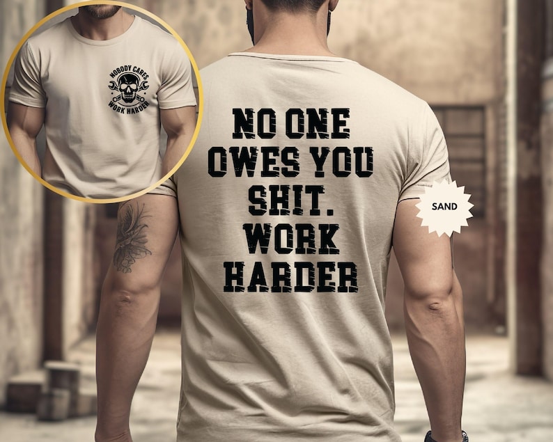 Op de afbeelding: Zandkleurig T-shirt met de zwarte tekst "NO ONE OWES YOU SHIT. WORK HARDER" op de achterkant. Een kleinere afbeelding op de voorkant toont een schedel met sleutels en de woorden "NOBODY CARES WORK HARDER".