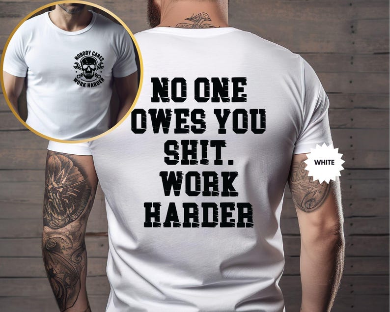 Op de afbeelding: Wit T-shirt met de tekst "NO ONE OWES YOU SHIT. WORK HARDER" in vette zwarte letters op de achterkant. De voorkant van het shirt heeft een schedel- en moersleutelafbeelding met de woorden "NOBODY CARES WORK HARDER".