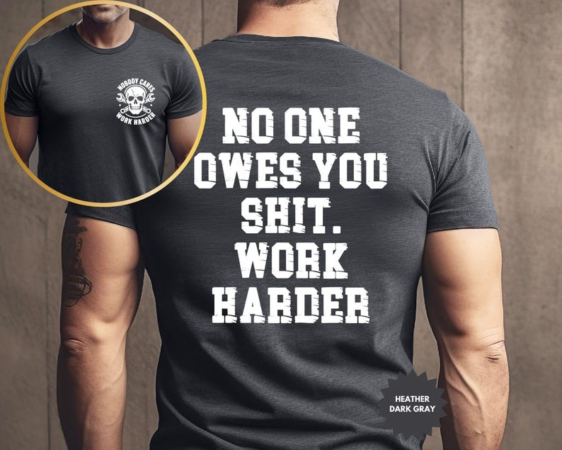 Op de afbeelding: Donkergrijze heather t-shirt met de witte tekst "NO ONE OWES YOU SHIT. WORK HARDER" op de rug. De voorkant toont een schedel- en moersleutelafbeelding met de tekst "NOBODY CARES WORK HARDER".