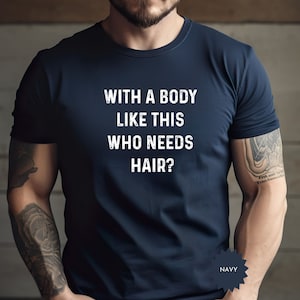 May include: A navy blue t-shirt with the text "With a body like this who needs hair?" printed in white.