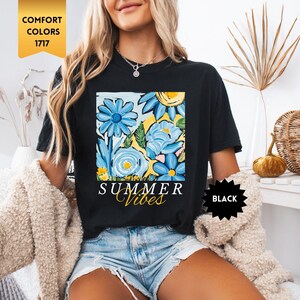 Peut inclure: T-shirt noir avec un motif de fleurs color&eacute;es et le texte "Summer Vibes".