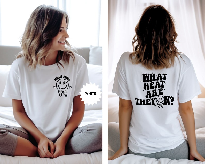 May include: White t-shirt with a black graphic on the front that says "Swim Mom" with a dripping smiley face. The back of the shirt has a black graphic that says "What heat are they on?" with a dripping smiley face.