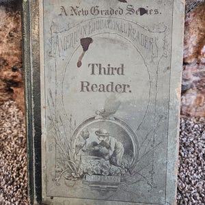 May include: Antique "Third Reader" book with a faded cover. The cover features the text "A New Graded Series" and "American Educational Readers." A small illustration depicts a person near water. The word "Temperance" is visible.