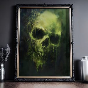 May include: A framed artwork featuring a glowing green skull against a dark background. The skull has a decaying appearance with dripping green accents. The frame is black with gold trim. The artwork is displayed on a wooden surface with decorative items.
