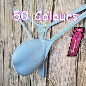 Könnte beinhalten: Hellblauer String-Tanga mit Beutel-Design, an einem goldenen Kleiderbügel. Der Text "50 Colours" befindet sich darüber. Ein pinkfarbenes Etikett mit "Jovana Design" ist sichtbar.
