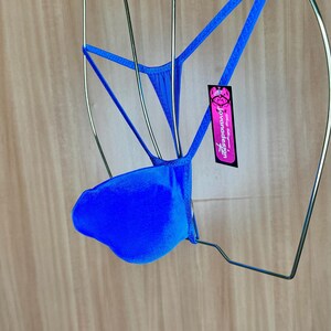 Op de afbeelding: Een helderblauwe, zijdeachtige string met een label met de tekst "Jovanadesign".