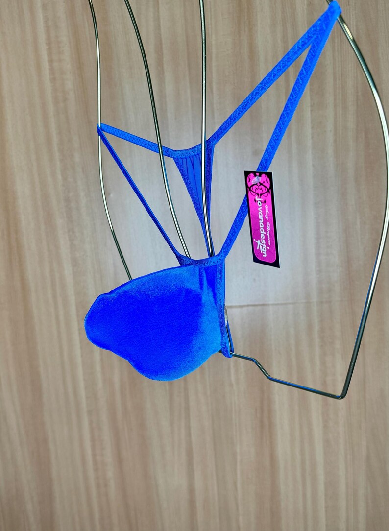 Op de afbeelding: Een helderblauwe, zijdeachtige string met een label met de tekst "Jovanadesign".