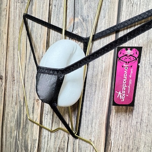 May include: Black lingerie with a mesh panel and a white tag that says "Jovanadesign" with a pink background.