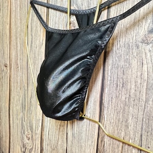 May include: Black satin lingerie with a low-rise cut and adjustable straps.