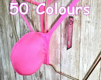 Op de afbeelding: Een fel neonroze string met dunne bandjes en een afgerond voorzakje, gepresenteerd op een goudkleurige draadbeugel. De tekst 50 Colours is in het wit met een roze omlijning over het beeld geplaatst en een zwart label jovanadesign is bevestigd.