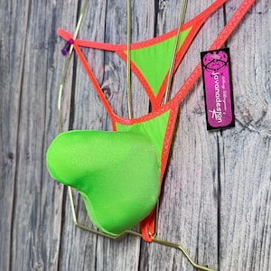 May include: Neon green and orange lingerie set. The thong-style bottom features a neon green pouch and is trimmed with orange. The top is a triangle design with orange trim. A tag with the text "jovanadesign" is attached.