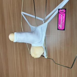May include: White jockstrap with a small tag that says "Jovanadesign" in pink lettering. The tag is attached to the strap with a gold metal ring.