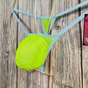May include: Light blue mesh underwear with a lime green pouch. The underwear is hanging on a gold hanger against a wood background.